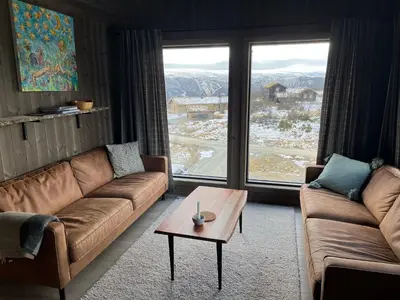 a living room with two couches and a coffee table at Luxurious Cabin, 5 Bedrooms, Sauna Stunning View in Beitostøl