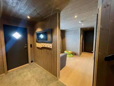 an empty room with a hallway with a tv on the wall at Luxurious Cabin, 5 Bedrooms, Sauna Stunning View in Beitostøl