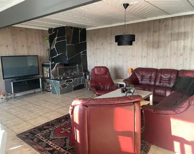 a living room with leather furniture and a flat screen tv at Peis, Utsikt Og 200 M Til Bakken in Beitostøl