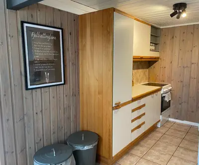 a kitchen with wooden walls and a chalkboard on the wall at Peis, Utsikt Og 200 M Til Bakken in Beitostøl