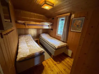 a small room with two beds and a window at Hjemmekoselig Hytte Ved Øyangen in Beitostøl