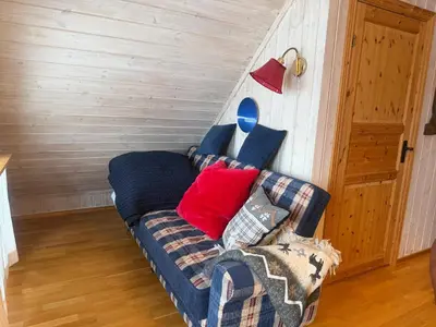 a living room with a couch with pillows at Koselig Leilighet Med Flott Utsikt in Beitostøl