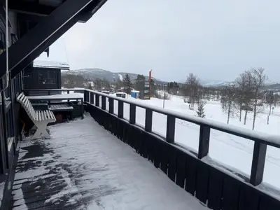 a snow covered porch of a building with a bench at Koselig Leilighet Med Flott Utsikt in Beitostøl