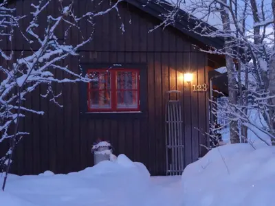 a log cabin with a fire hydrant in the snow at Familievennlig Hytte Rett Ved Sentrum in Beitostøl