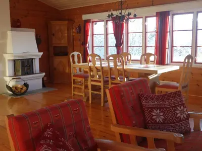 a dining room with a table and chairs and a fireplace at Familievennlig Hytte Rett Ved Sentrum in Beitostøl