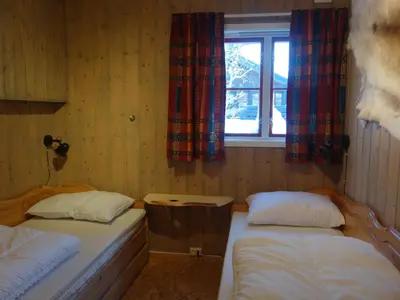 two beds in a room with a window at Familievennlig Hytte Rett Ved Sentrum in Beitostøl