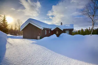 a house covered in snow with a pile of snow at Relax And Unwind At Slettero-A Cozy Family Getaway in Beitostøl