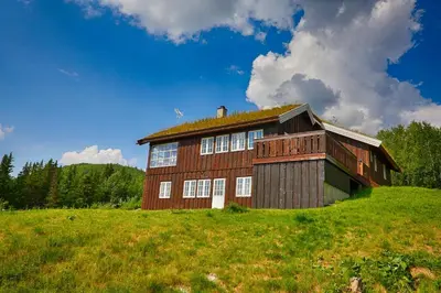 a barn on top of a grassy hill at Relax And Unwind At Slettero-A Cozy Family Getaway in Beitostøl