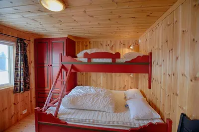 a bedroom with two bunk beds in a wooden wall at Relax And Unwind At Slettero-A Cozy Family Getaway in Beitostøl