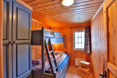 a small room with a bed in a wooden house at Relax And Unwind At Slettero-A Cozy Family Getaway in Beitostøl
