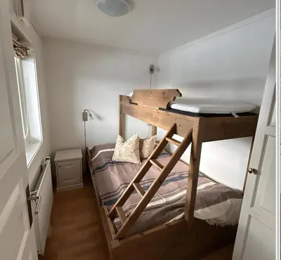 a bunk bed in a small room with a desk at Familievennlig Leilighet Med 7 Sengeplasser in Beitostøl