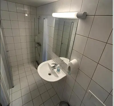 a white bathroom with a sink and a mirror at Familievennlig Leilighet Med 7 Sengeplasser in Beitostøl