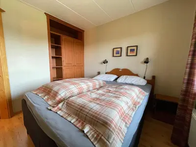 a bedroom with a bed with a plaid blanket at 3-Roms Leilighet Nær Alle Beitostølens Fasiliteter in Beitostøl