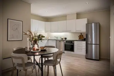 a kitchen with a table and a stainless steel refrigerator at Nice apartment near the city center! in Bergen