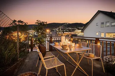 a table and chairs on a balcony with a view at Nice apartment near the city center! in Bergen