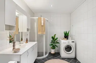 a bathroom with a washing machine and a sink at Nice apartment near the city center! in Bergen