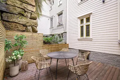 a patio with a table and chairs and a building at Fantastic village apartment in Bergen in Bergen