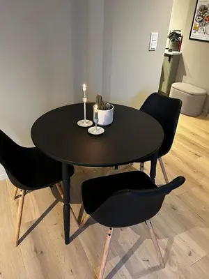 a black table with two chairs and a candle on it at Fantastic village apartment in Bergen in Bergen