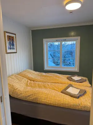 a bedroom with a large bed with a window at Huset i den lykkelige gaten in Elverum
