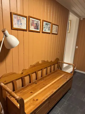 a wooden bench in a room with pictures on the wall at Huset i den lykkelige gaten in Elverum
