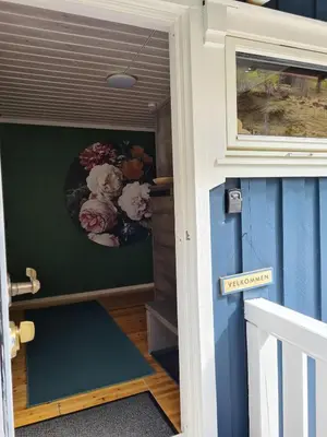a door to a house with a flower arrangement on the wall at Nordfjordcabins BLUE in Utvik