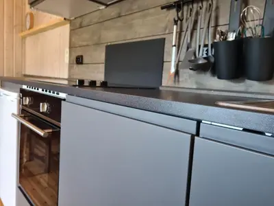 a kitchen with white cabinets and a counter top at Nordfjordcabins BLUE in Utvik