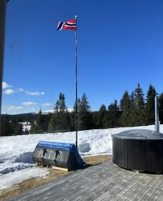 a flag on top of a building with snow at Mountain cabin in Lillehammer in Lillehammer