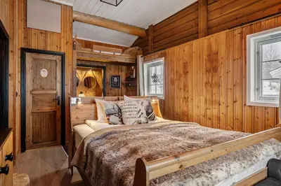 a bedroom with a bed in a wooden wall at Trysilfjell hytteomrade 589 in Hovi