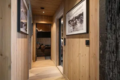 a hallway in a house with wooden walls and wood floors at FJELLRO Private Alpine Lodge Høgevarde in Flå