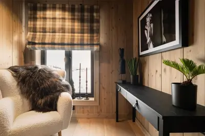 a cat sitting in a chair in a room with a window at FJELLRO Private Alpine Lodge Høgevarde in Flå