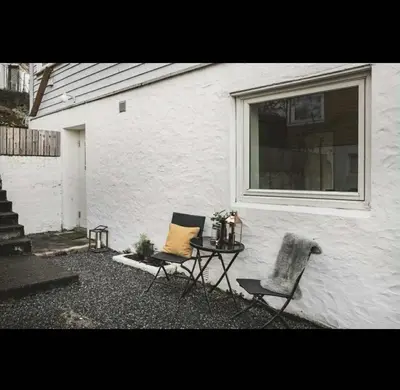 two chairs and a table in front of a building at Bright and modern apartment close to the city center! 2 bedroom in Bergen