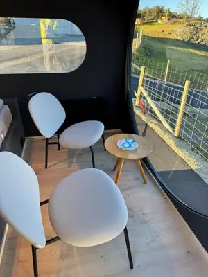 three white chairs and a table and a window at Langelandsvik Gard Birdbox