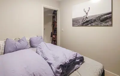a bedroom with a bed with purple sheets and a picture on the wall at 3 Bedroom Beautiful Apartment In Voss in Vossevangen
