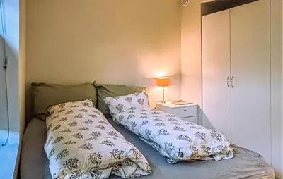 a bedroom with a bed with pillows and a night stand at 3 Bedroom Beautiful Apartment In Voss in Vossevangen