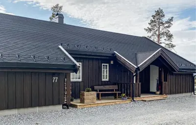 a large black barn with a bench in front of it at Stunning Home In Bjorli With Sauna in Bjorli