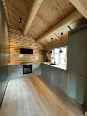 a kitchen with wooden walls and a wooden ceiling at Gunhild-stugu