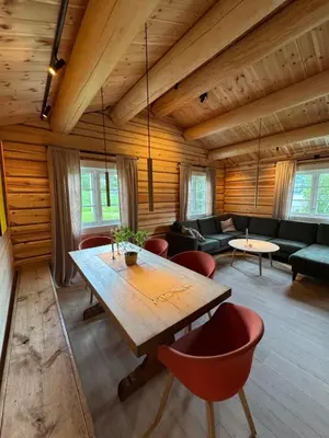 a living room with a wooden table and chairs at Gunhild-stugu