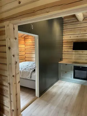 a bedroom with a bed in a room with wooden walls at Gunhild-stugu