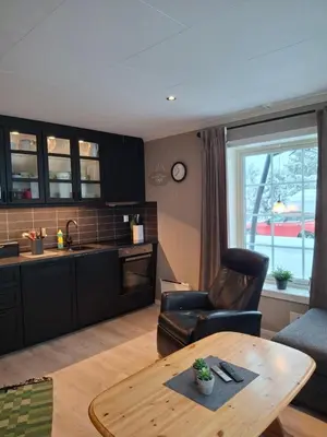 a living room with a table and a kitchen at Bjørgebu Camping AS in Nord-Fron