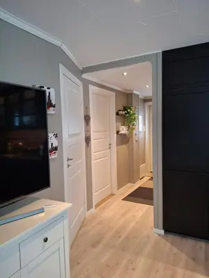 a living room with a flat screen tv and a hallway at Bjørgebu Camping AS in Nord-Fron