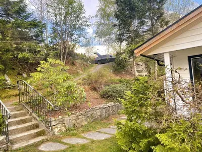 a driveway of a house with a car driving down a hill at Holiday Home Fjordtraum by Interhome in Balestrand