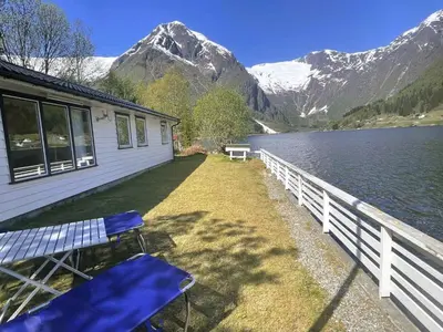 a house with a bench next to a body of water at Holiday Home Fjordtraum by Interhome in Balestrand