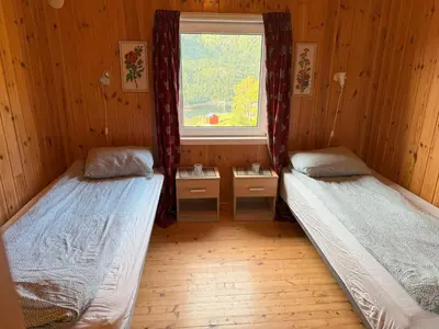 two beds in a room with a window at Holiday Home Stabben Blue House by Interhome in Storsæter