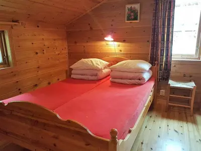 a bedroom with a bed in a log cabin at Holiday Home mit Blick auf das Wasser by Interhome in Hebnes