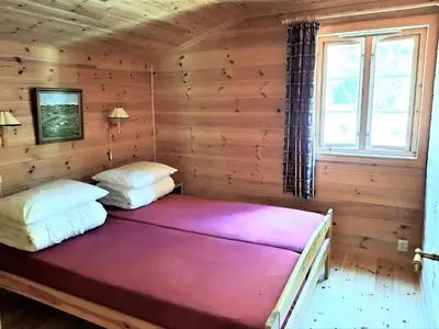 a bedroom with two beds in a log cabin at Holiday Home Ein Traumstandort by Interhome in Hebnes