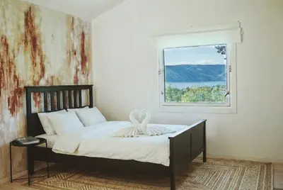 a bed in a room with a window at Romantic Getaway Hot Tub, Cinema & View in Stange