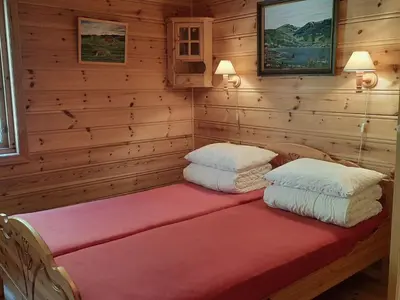 a bed in a log cabin with two pillows on it at Holiday Home Häuschen mit Blick auf das Wasser by Interhome in Ropeid