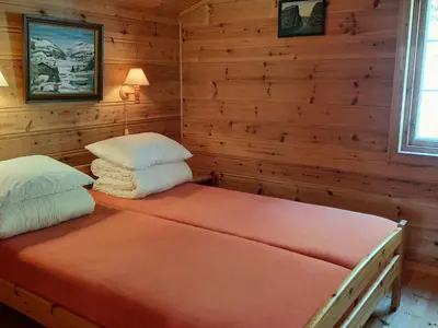 a bedroom with a bed with two pillows at Holiday Home Häuschen mit Blick auf das Wasser by Interhome in Ropeid