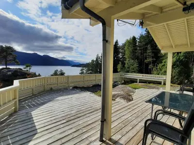 a wooden deck with a view of a lake at Holiday Home Häuschen mit Blick auf das Wasser by Interhome in Ropeid
