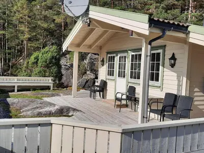 a porch of a house with chairs and a table at Holiday Home Häuschen mit Blick auf das Wasser by Interhome in Ropeid